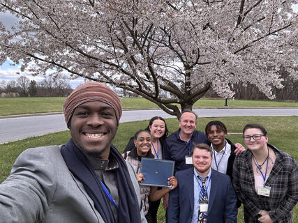 Kramoh Mansalay taking an outdoor selfie with the four other student presenters along with Professor Craig.