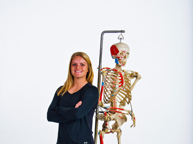 Olivia Maenner standing next to a lab skeleton.