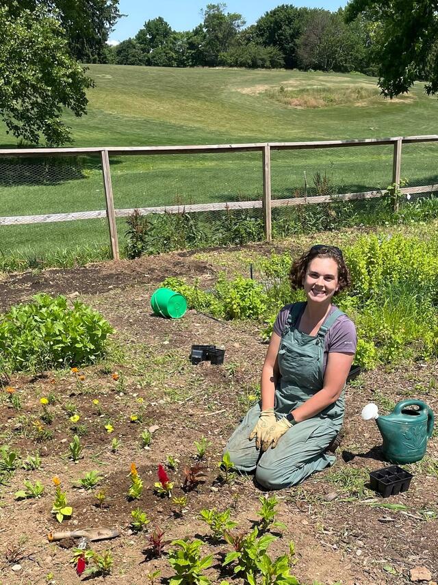 Elly Engle posing in a garden that she is planting in.
