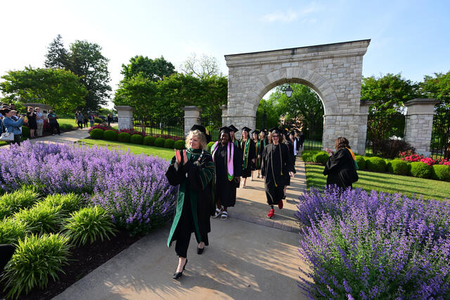 President Julia Jasken leads students through the Arch