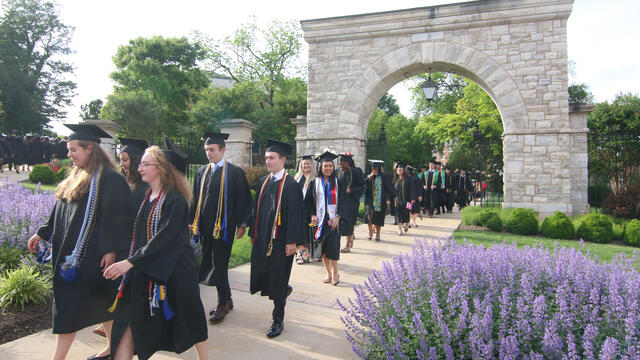 Graduates walking through the Arch at Convocation.