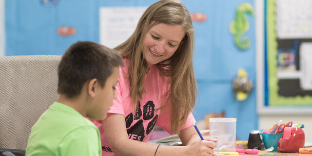 Student teaching one-on-one in elementary school setting.