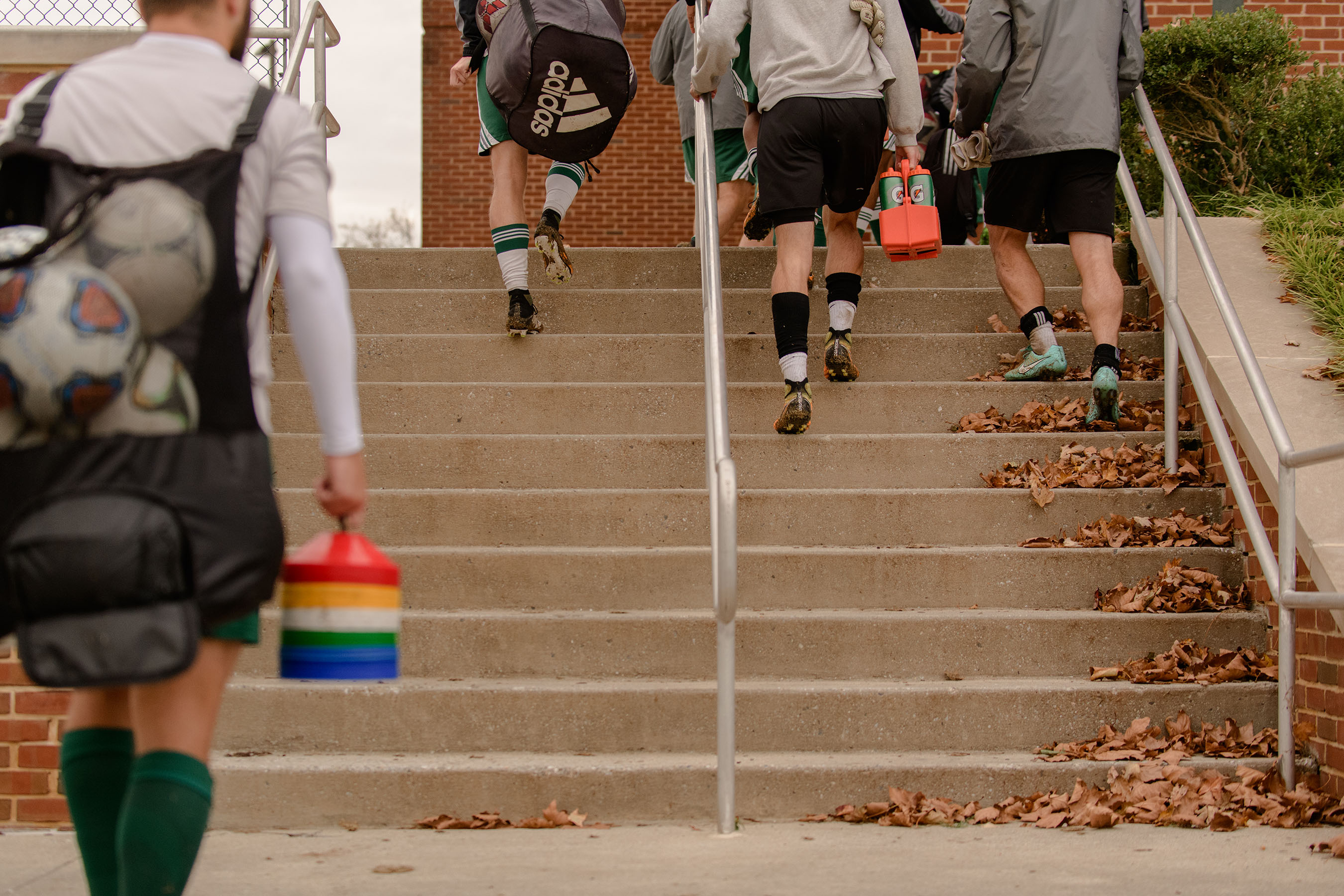 Athletes climbing staircase on campus.