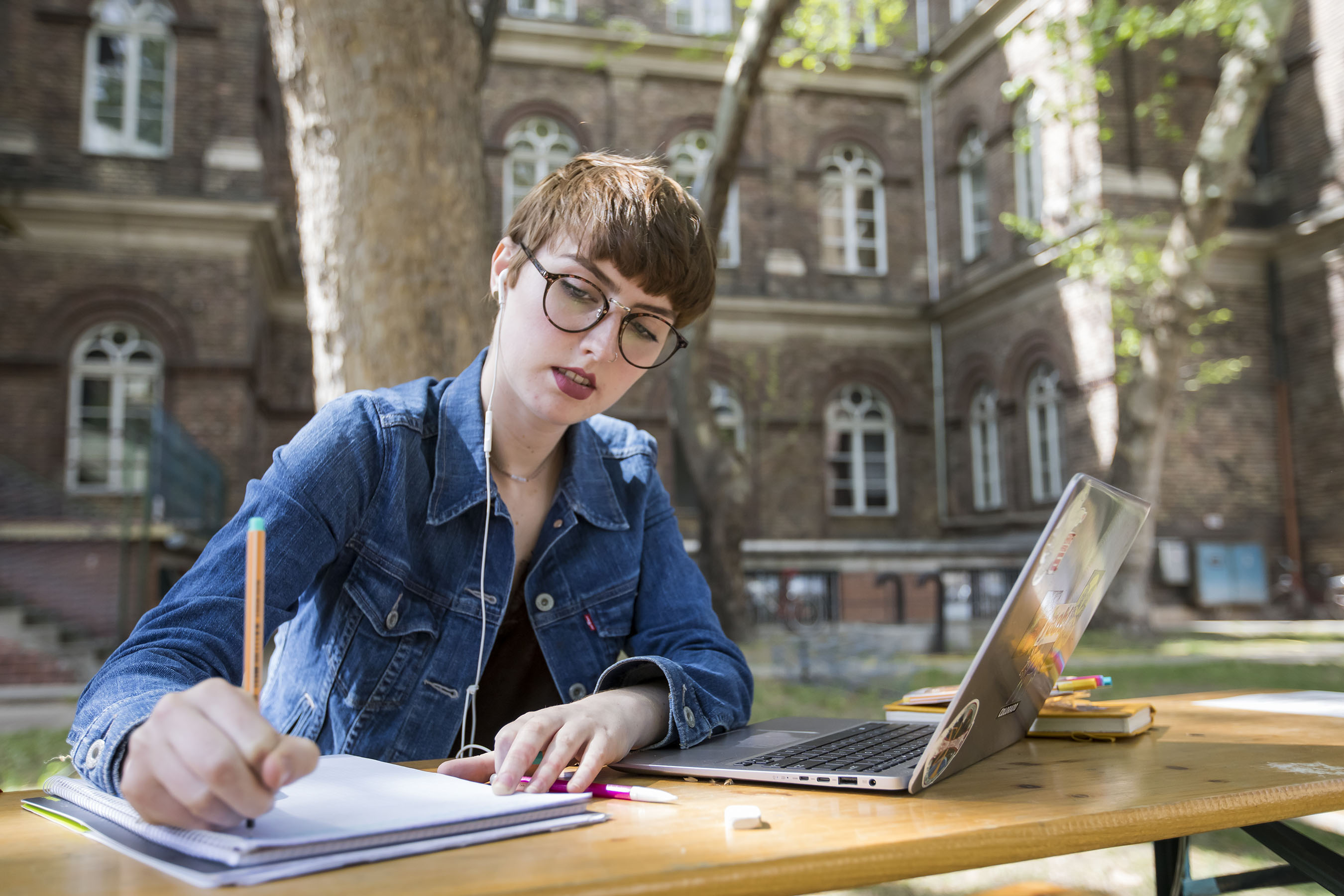 Student writing in notebook outside of Budapest campus.