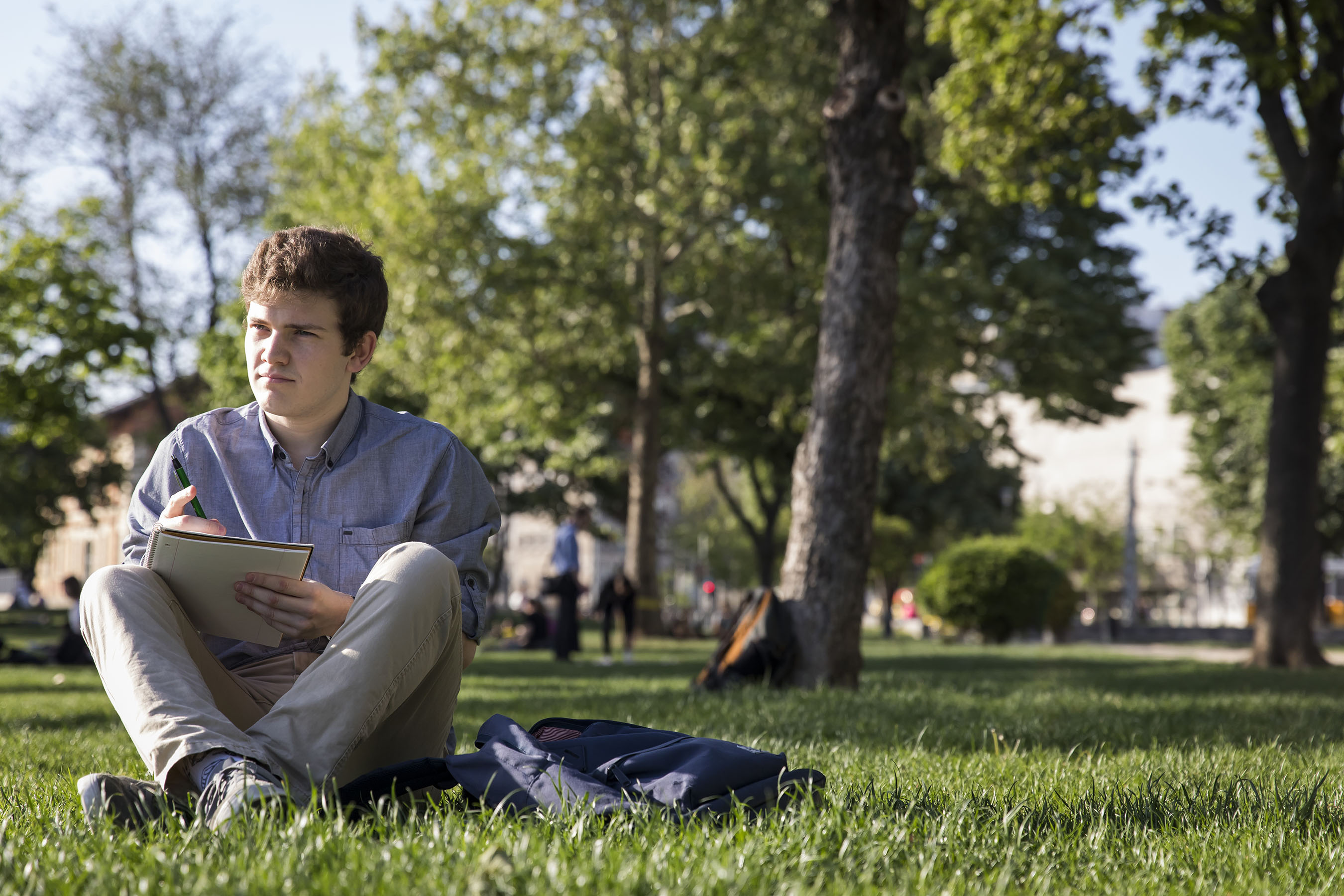 Student writing in notebook outside of Budapest campus.