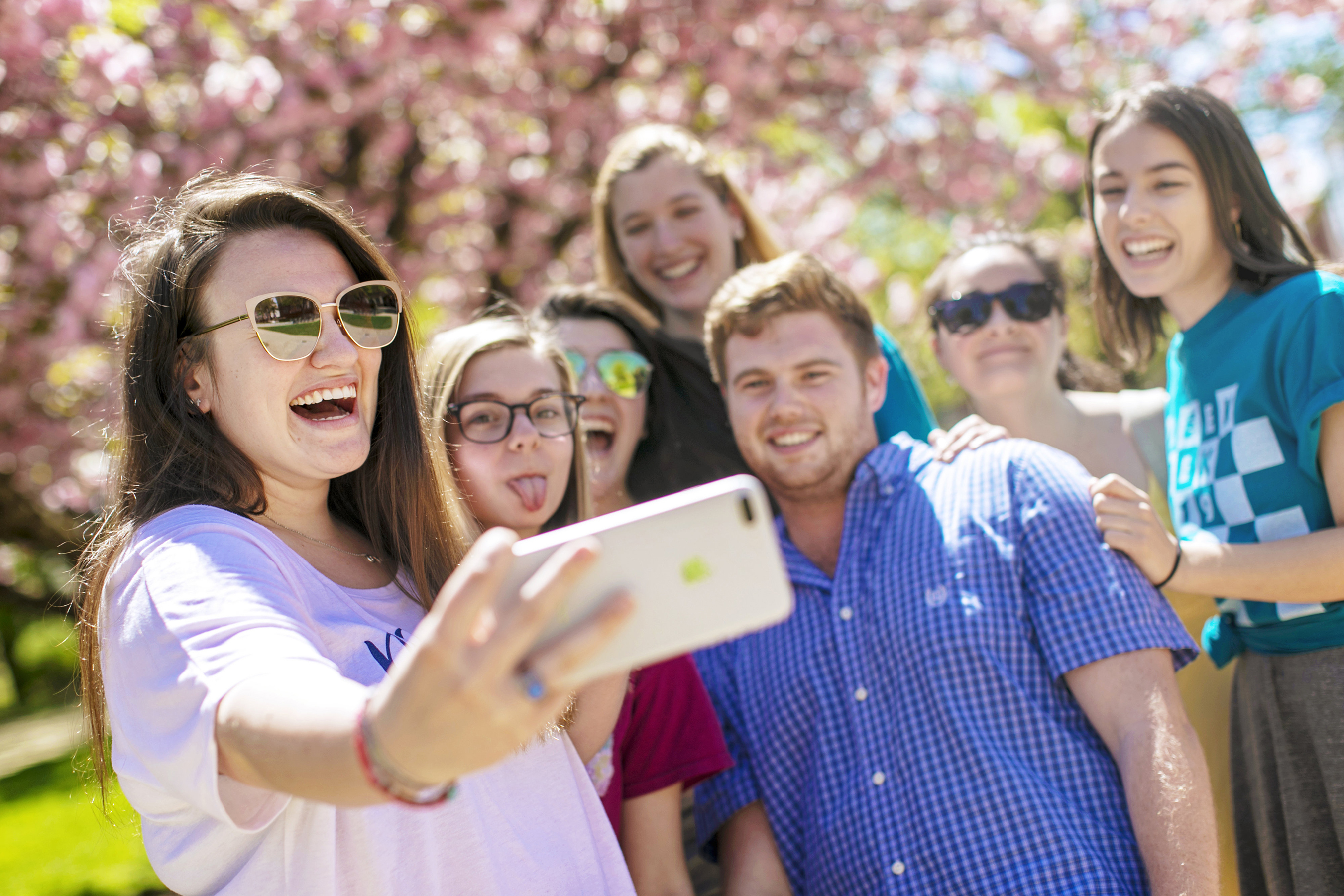 Students taking group selfie outside on campus.