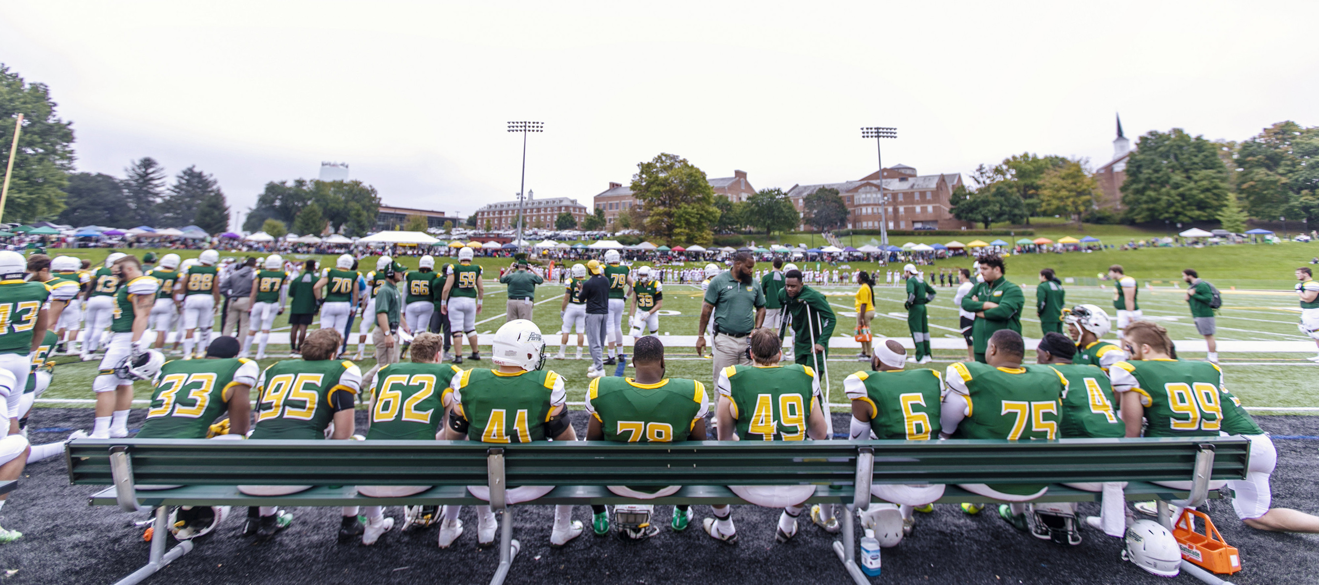 Football players sitting on the bench during football game.