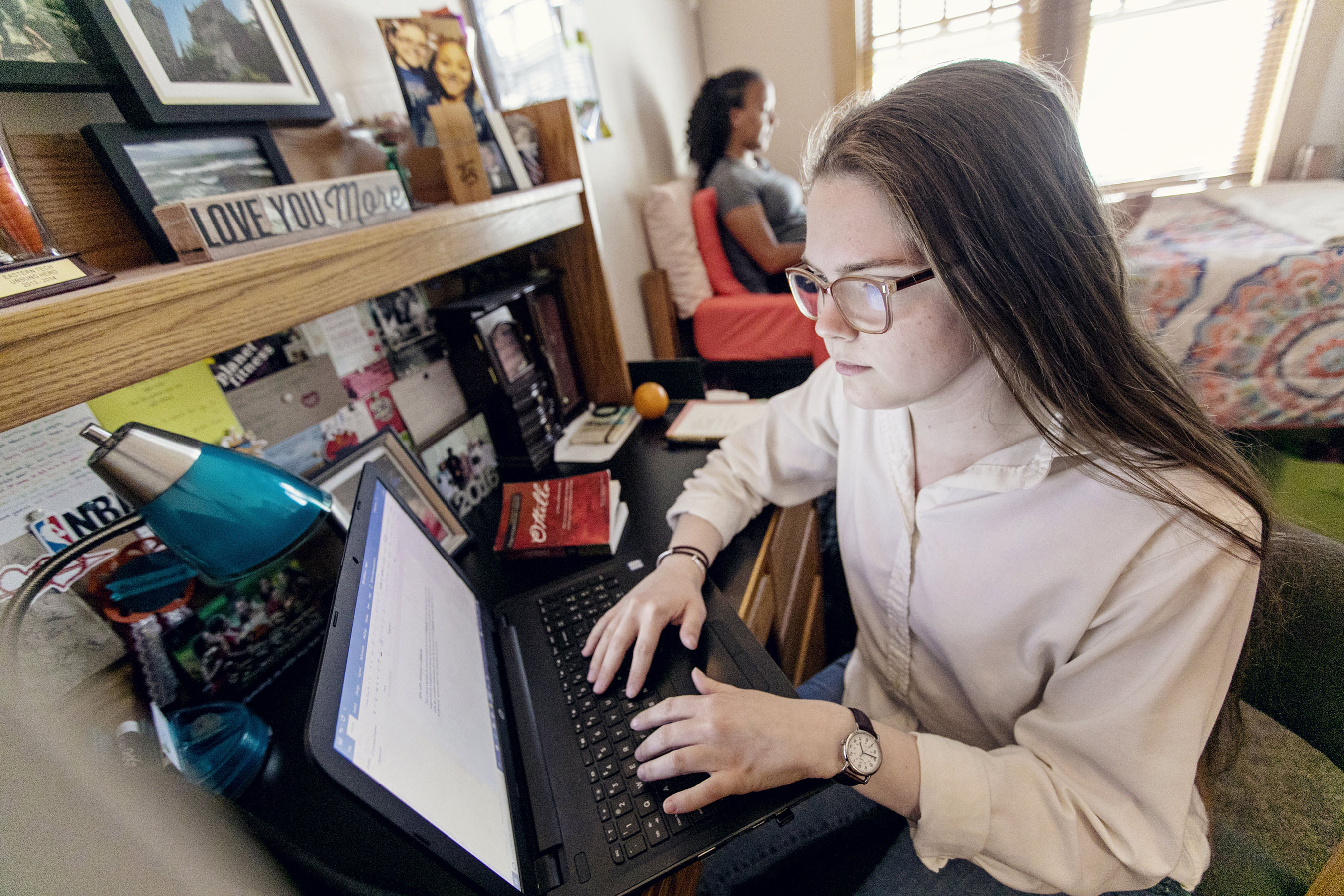 Students on computers in residence hall room.