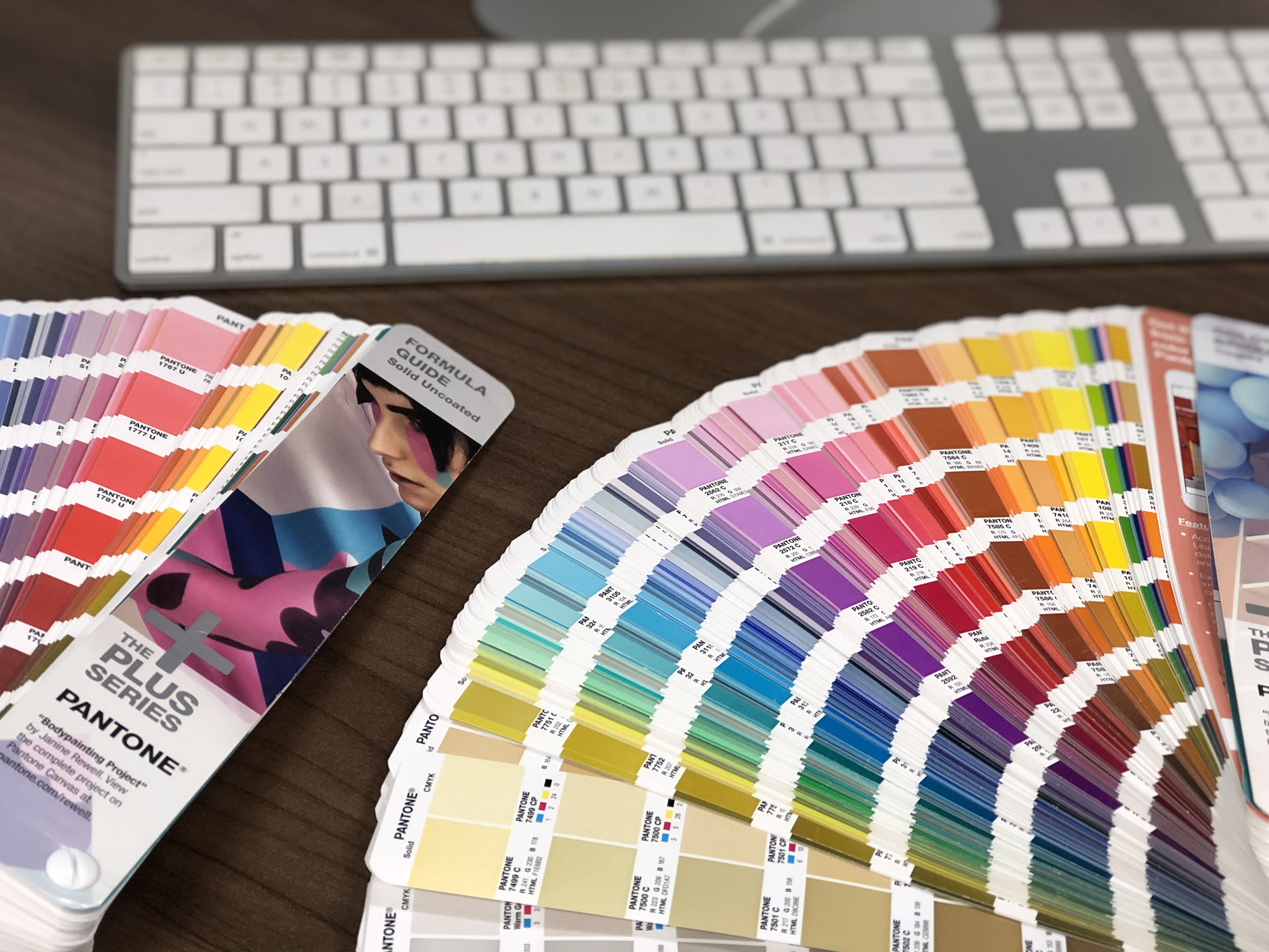 Pantone color books open on table.
