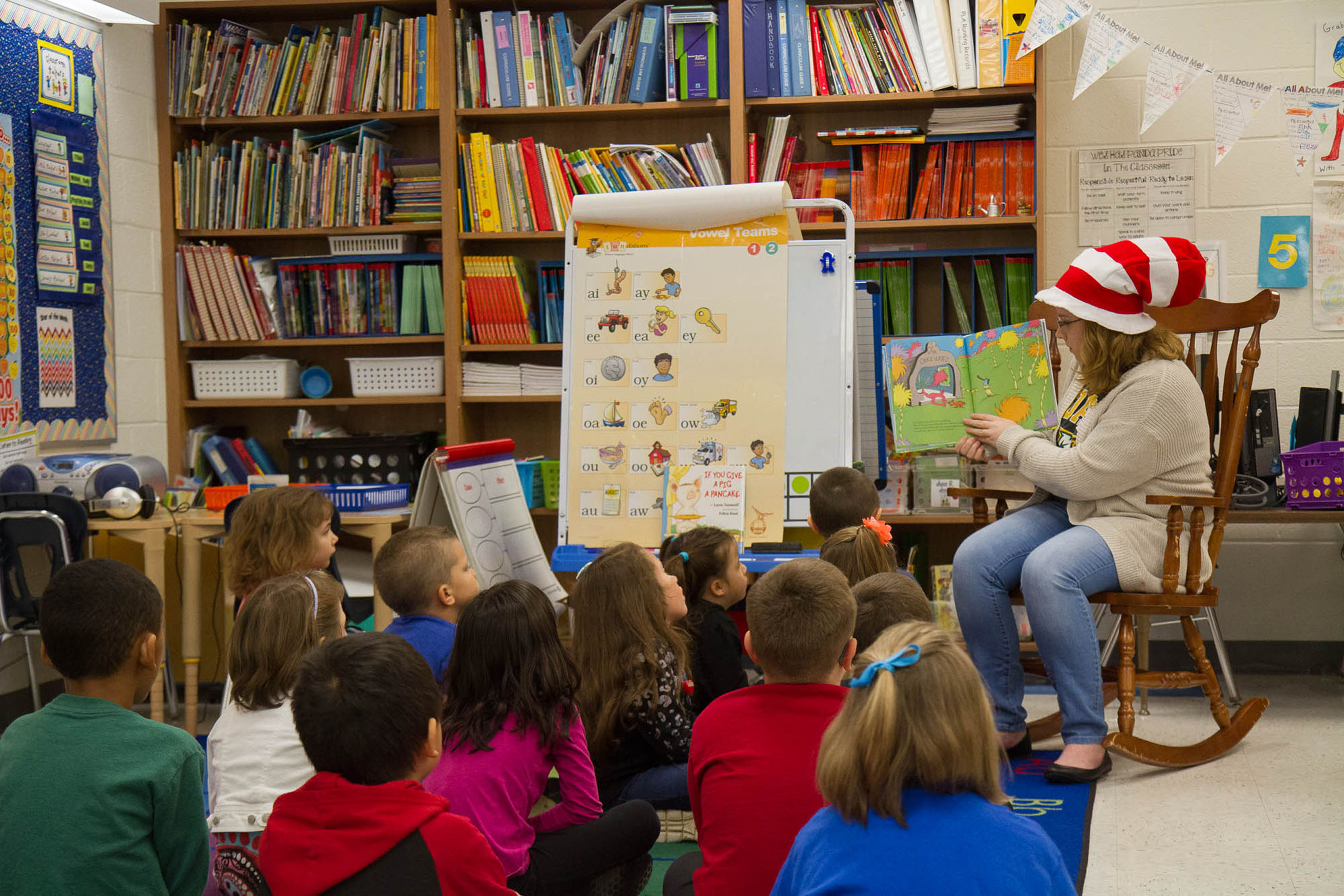 Student reading to a classroom full of elementary school children.