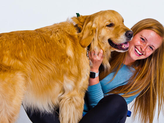 Morgan Collinson, petting a golden retriever