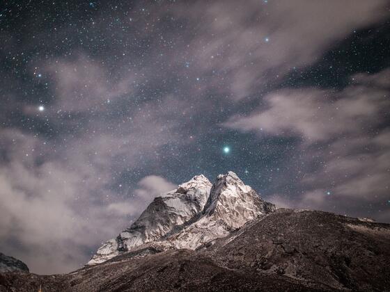 Clouds and stars over a mountain