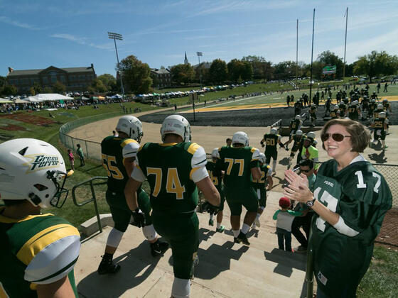 Football players walking down the steps to the field.