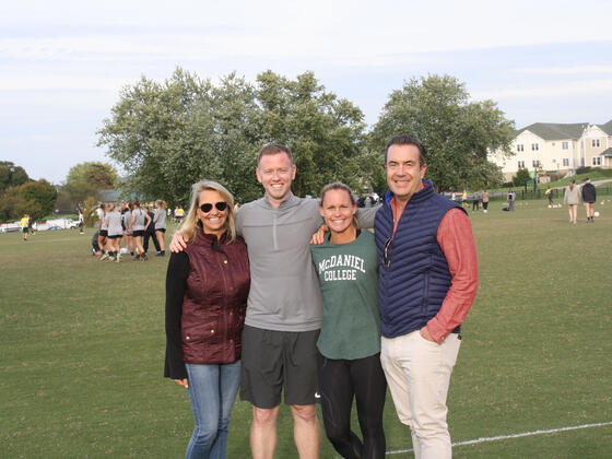 Christie Pearce Rampone and Steven Hegna Group on field.