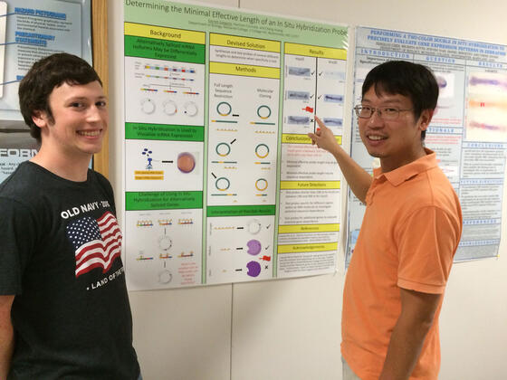 Senior Garrett Gregoire discusses his research with Biology professor Cheng Huang.