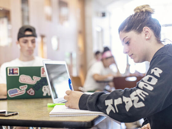 Students with notebooks and computers.