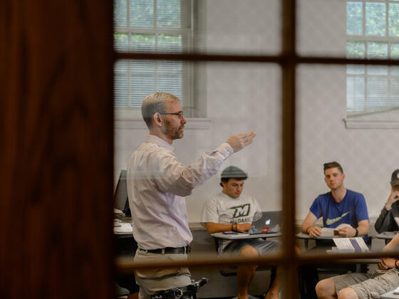 Professor lecturing in front of class.