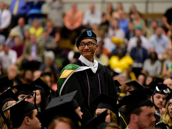 Student standing to be recognized during commencement ceremony.