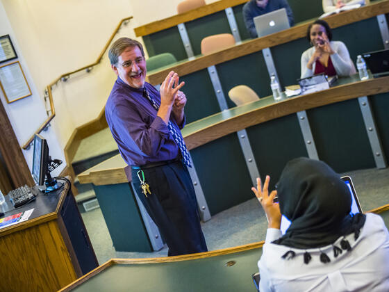 Grad professor lecturing in front of class.