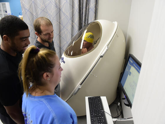 Students with professor in Kinesiology lab.
