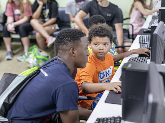 Student interacting with child at the Boys and Girls Club in Westminster.