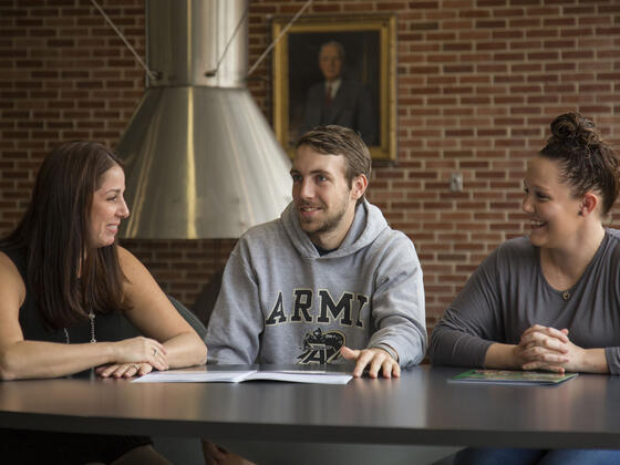 Students in conversation sitting at table.