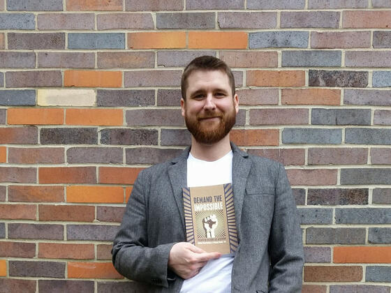 Nathan Wuertenberg standing in front of a brick wall.