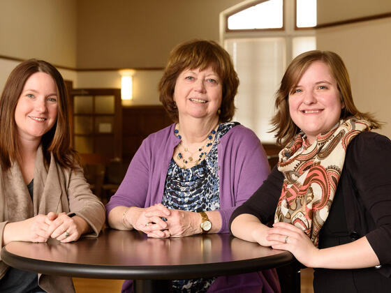 Alumnae poets Bothe Meadows Mangan Mercer sitting at table.