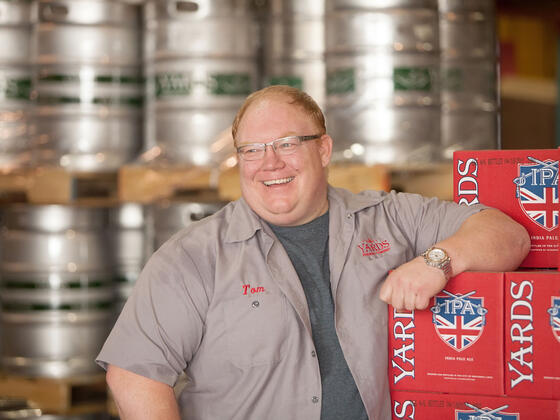 Tom Kehoe standing in front of Yards Brewing inventory.