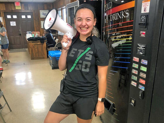 Student smiling and holding a megaphone.