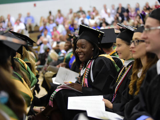 Graduates in cap and gown seated for Commencement.