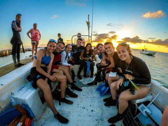 Students on boat about to go scuba diving during study abroad experience.