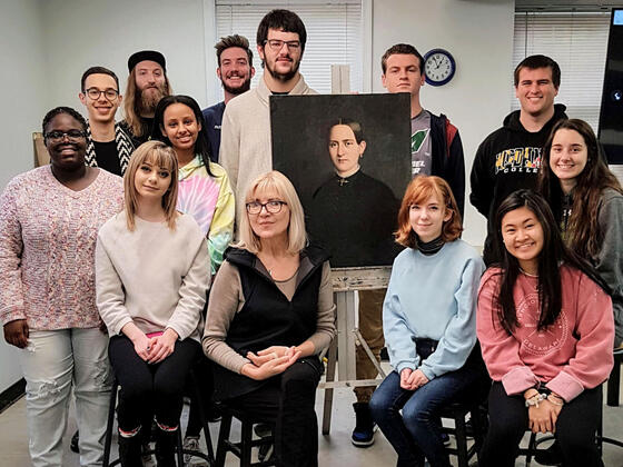 Professor and students gathered around “Portrait of the Lady” painting after restoration.