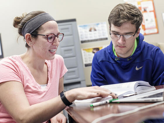 Graduate assistant working with student.