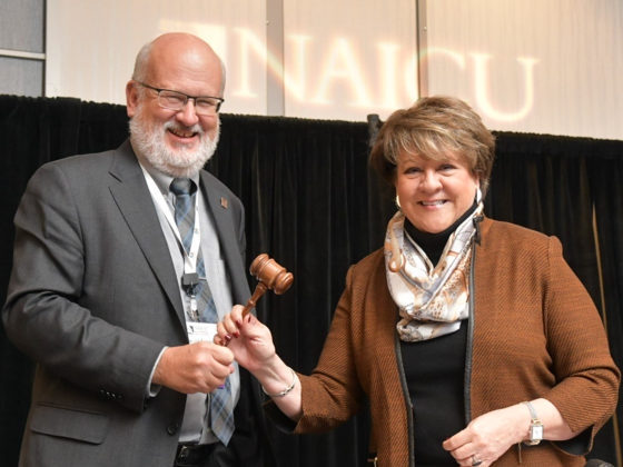 President Roger N. Casey accepts the NAICU Board Chair gavel from outgoing Chair Jo Allen, president of Meredith College (NC).