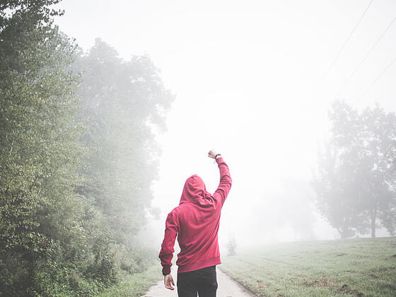 boy walking alone in the fog
