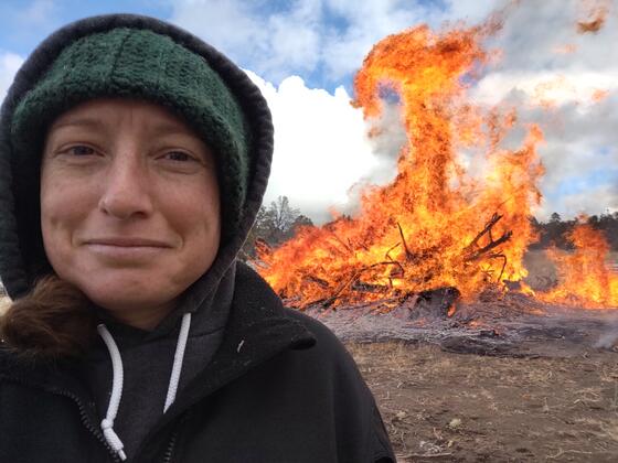 Ellen Larsen '10 in front of a bonfire