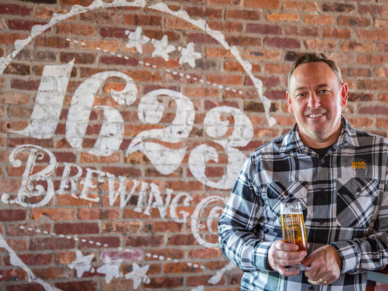 Mike McKelvin in front of the sign for 1623 Brewing.