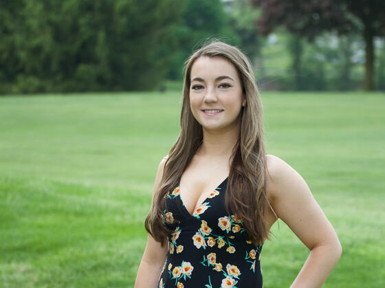 Alumna Caitlin Eversmier '18 in a grassy field.