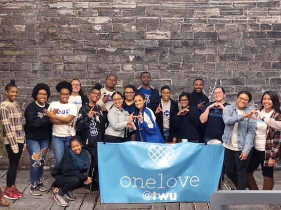 Students in the One Love student group at TWU pose with the One Love sign.