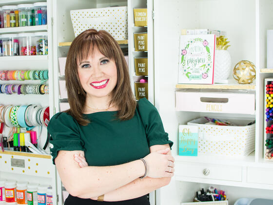 Alumna Amy Latta poses in front of bookshelves.