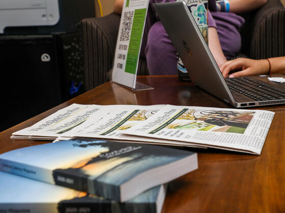 Photo of literary journal and newspapers on a table in the Writing Center.