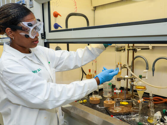 A student demonstrates a chemistry process in the lab.
