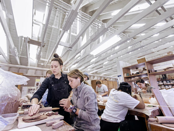 Two students work on a clay project in the McDaniel art studio.