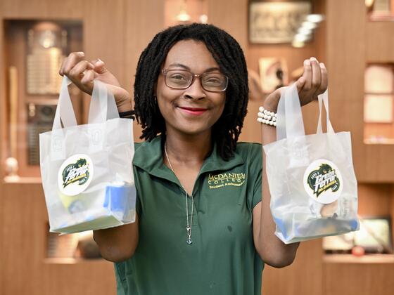 Student holding Green Terror gift bags.