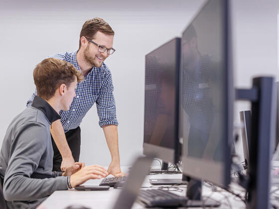 CEO staff and student look at computer screen