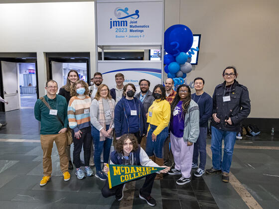 People stand in front of sign as a group 