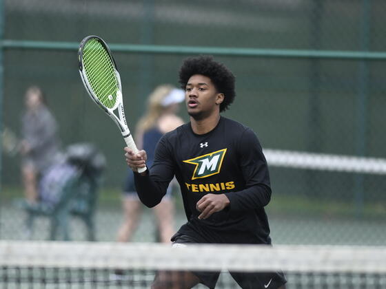 Photo of a student swinging a tennis racket.