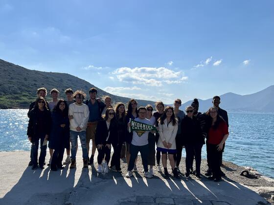 People stand in front of blue sky with water