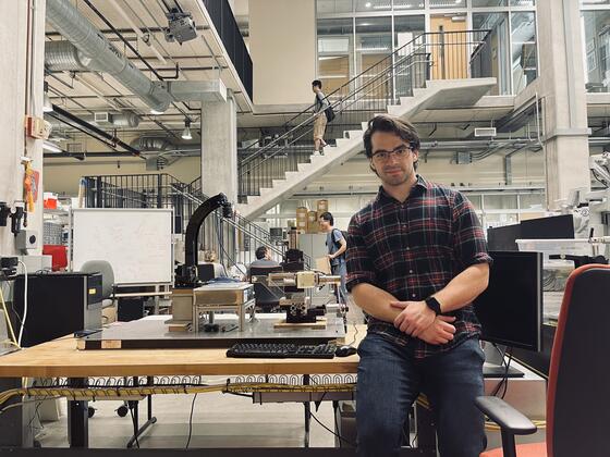 Photo of alum Dimitri Lezcano sitting in a laboratory.